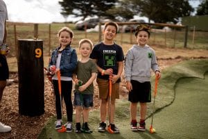 Photo of children standing and smiling at a Shanx Mini Golf Course